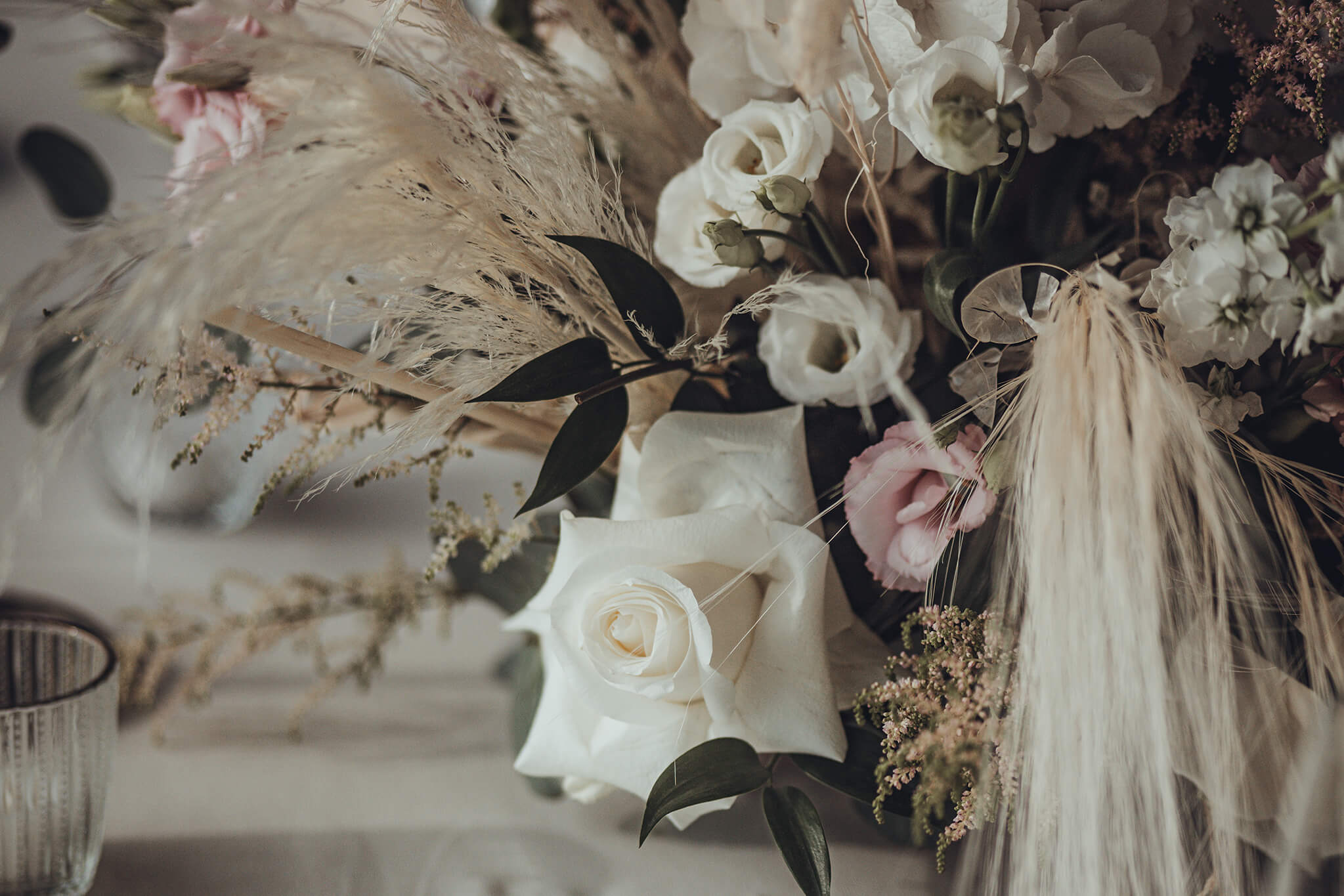 Hochzeits Boho Tischdekoration mit weißen Rosen und Pampas